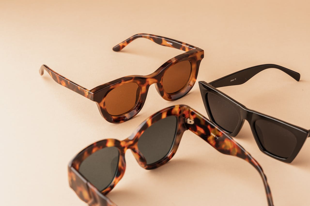 Premium tortoiseshell and black sunglasses displayed elegantly on a neutral background.