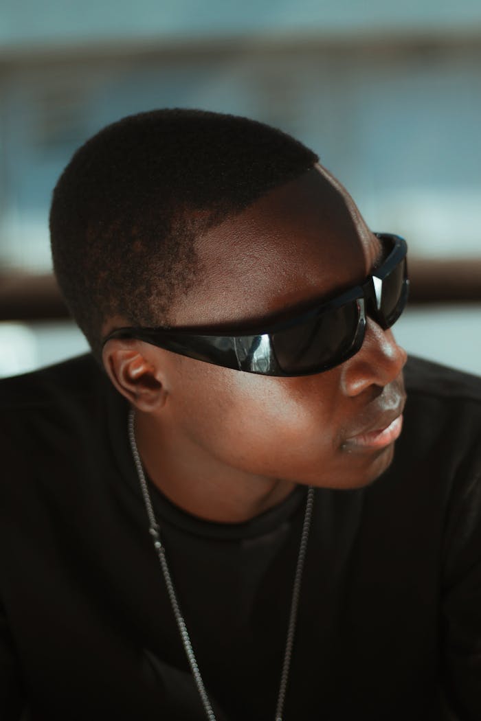 Cool portrait of a man wearing dark sunglasses indoors, exuding style and confidence.